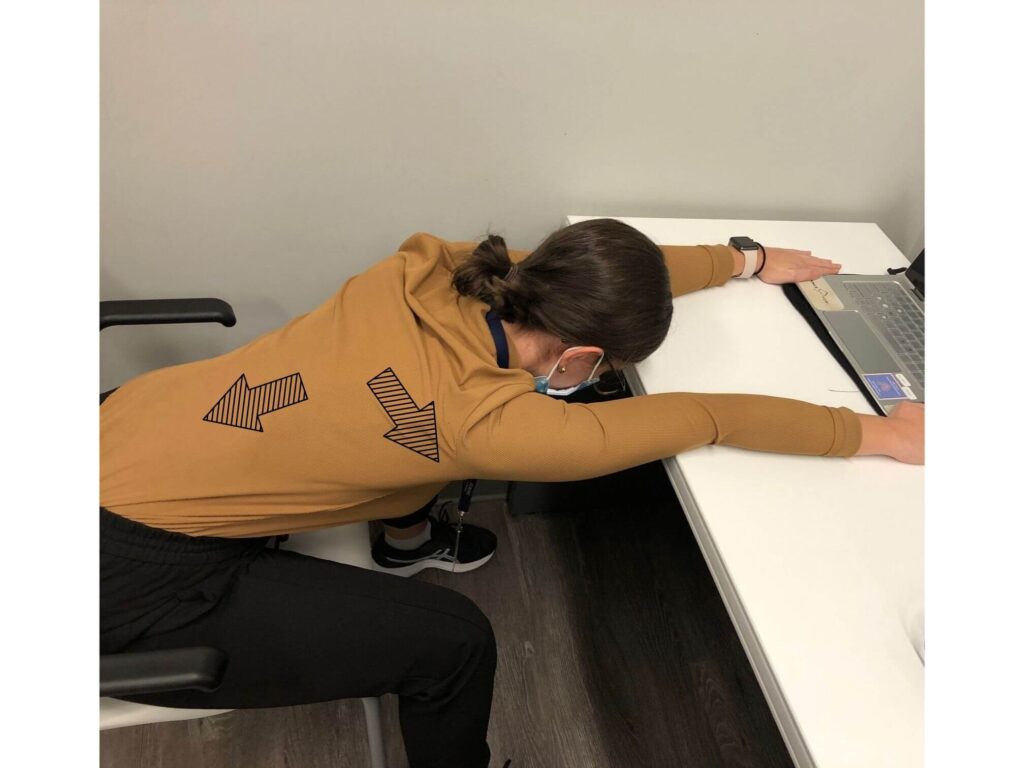Back and shoulder stretch with hands on desk and sliding back in chair